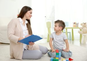 young-child-psychologist-working-with-little-boy-scaled